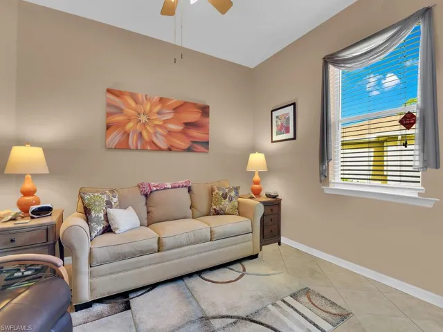 Living room with ceiling fan and light tile patterned floors