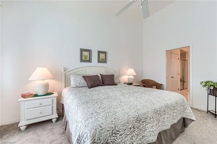 Bedroom with baseboards, a high ceiling, and light colored carpet