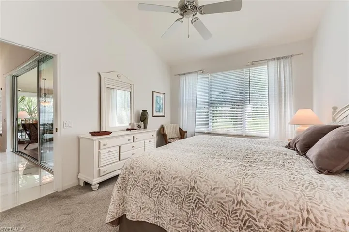 Bedroom featuring access to exterior, light carpet, baseboards, high vaulted ceiling, and ceiling fan