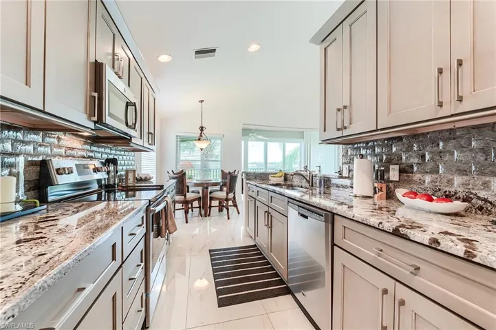 Kitchen featuring tasteful backsplash, visible vents, appliances with stainless steel finishes, and a sink