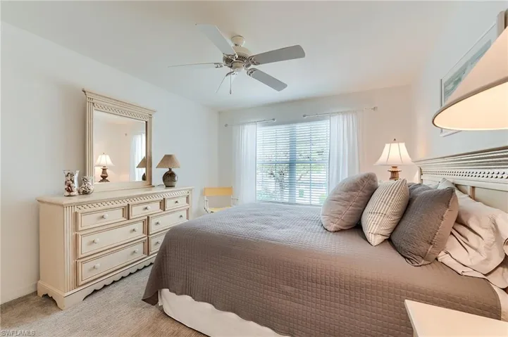 Bedroom with light colored carpet, ceiling fan, and baseboards