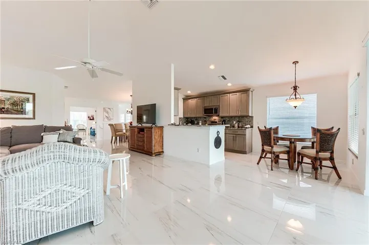 Living room featuring recessed lighting, a healthy amount of sunlight, marble finish floor, and a ceiling fan