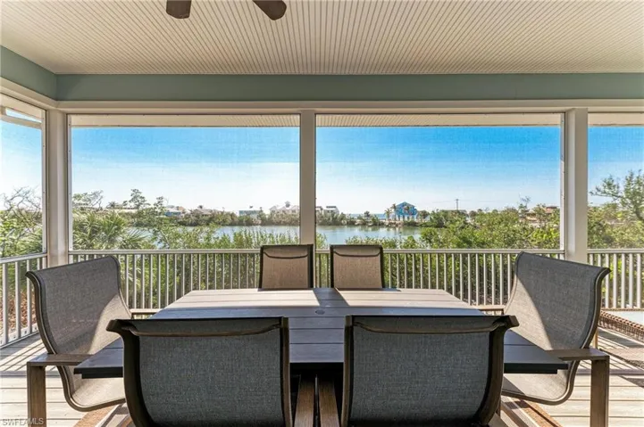 Sunroom with a water view, a healthy amount of sunlight, and ceiling fan