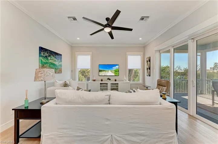 Bedroom with light hardwood / wood-style flooring, crown molding, access to outside, and ceiling fan
