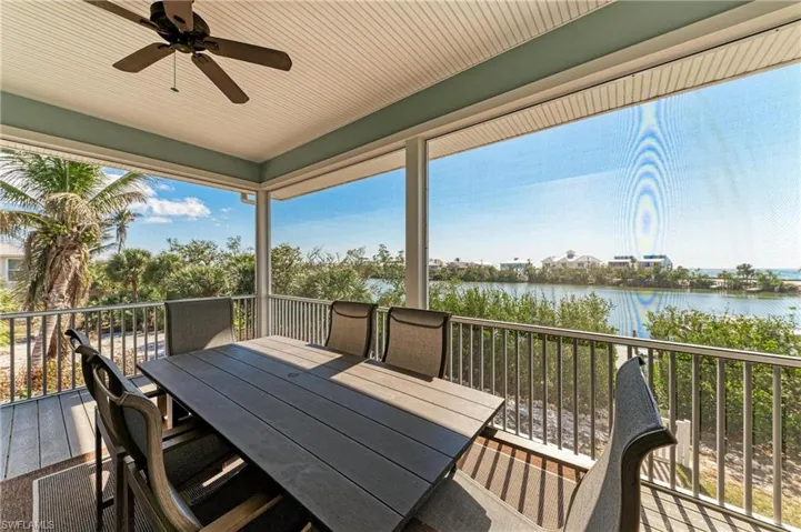 Wooden terrace featuring ceiling fan and a water view