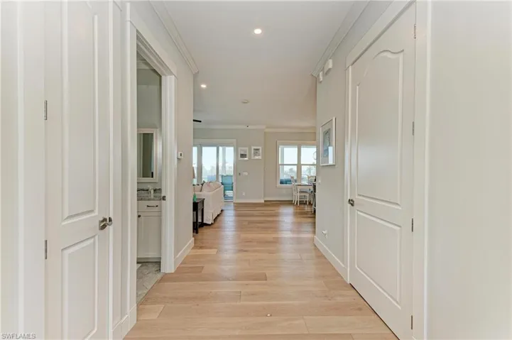 Hall featuring ornamental molding and light wood-type flooring