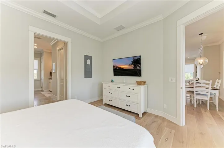 Bedroom featuring crown molding, multiple windows, and light wood-type flooring
