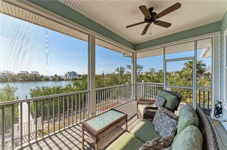 Sunroom featuring a water view and ceiling fan