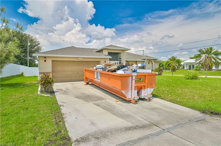 View of front facade featuring a front yard and a garage