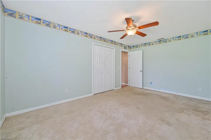 Unfurnished bedroom with ceiling fan, carpet, and a closet