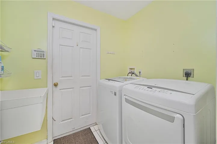 Washroom featuring light tile patterned floors and washer and clothes dryer