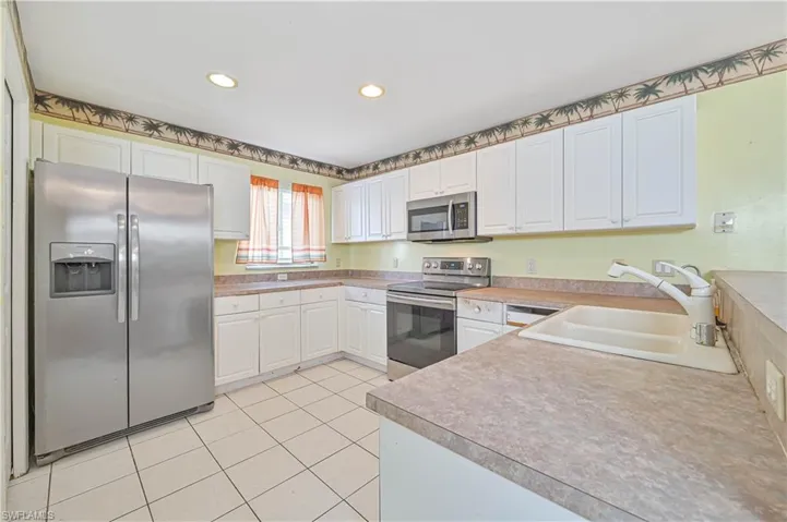 Kitchen featuring white cabinetry, appliances with stainless steel finishes, and sink