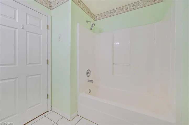 Bathroom with shower / bathtub combination and tile patterned floors
