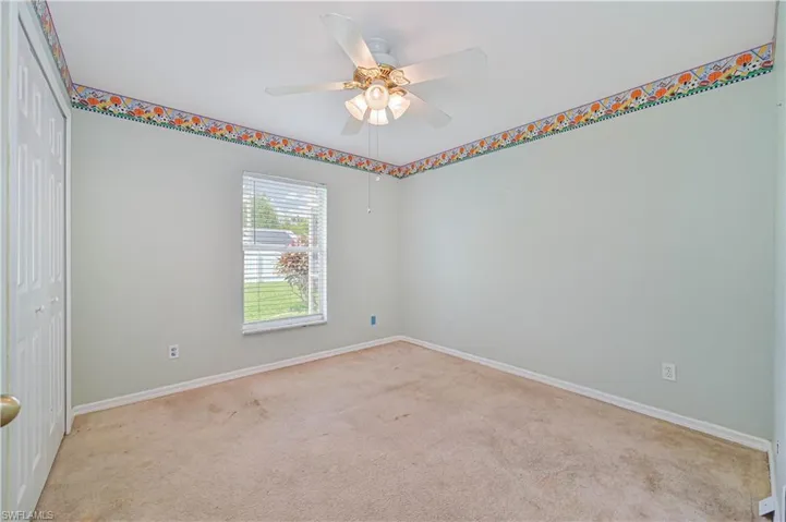 Carpeted spare room with ceiling fan