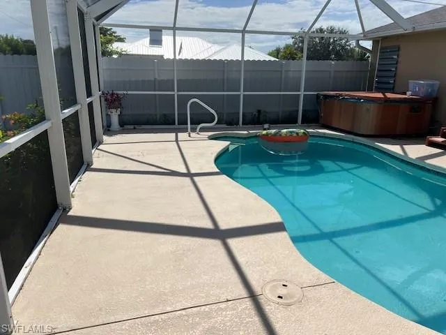 View of swimming pool featuring a patio, a lanai, and a hot tub