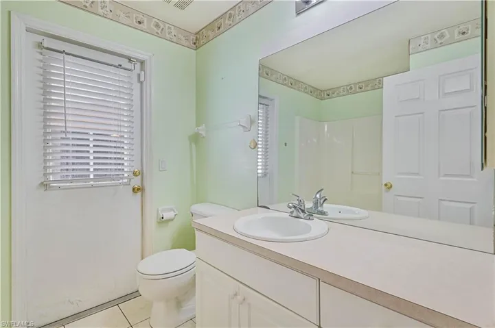 Bathroom featuring tile patterned flooring, toilet, and vanity