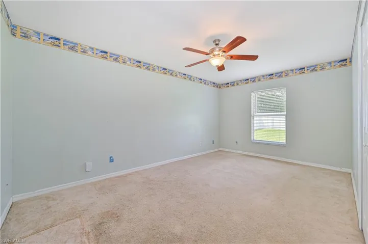 Carpeted spare room featuring ceiling fan
