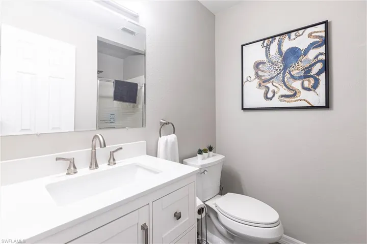 Full common area bathroom with vanity, toilet, visible vents, and walk in shower