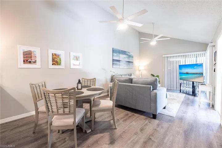 Dining room with a textured ceiling, wood finished floors, baseboards, and lighted ceiling fan and all new furniture.