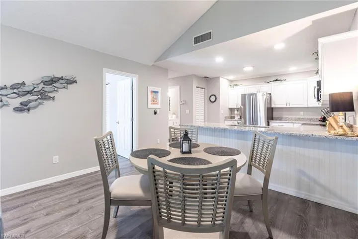 Cute dining room with light wood-type flooring, recessed lighting and lofted ceiling