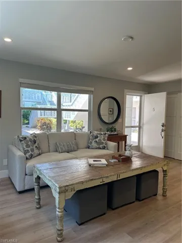 Living area with baseboards, recessed lighting, and light wood-style floors