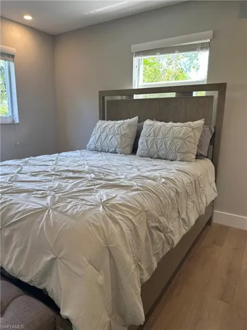 Bedroom with multiple windows, recessed lighting, wood finished floors, and baseboards