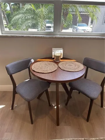 Dining area featuring baseboards, a healthy amount of sunlight, and wood finished floors