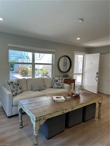 Living area with light wood-style floors and recessed lighting