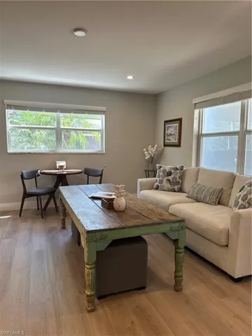 Living area with baseboards, wood finished floors, and recessed lighting