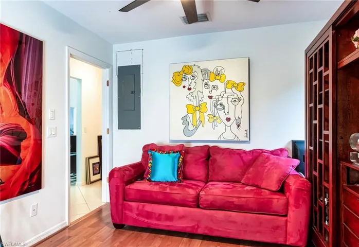 Living room featuring hardwood / wood-style flooring, ceiling fan, and electric panel