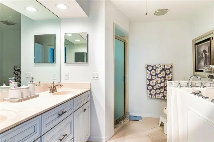 Bathroom with tile patterned floors, a shower with door, vanity, and toilet