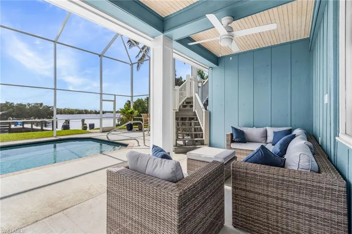 View of patio featuring glass enclosure, stairway, an outdoor pool, a sunroom, and ceiling fan
