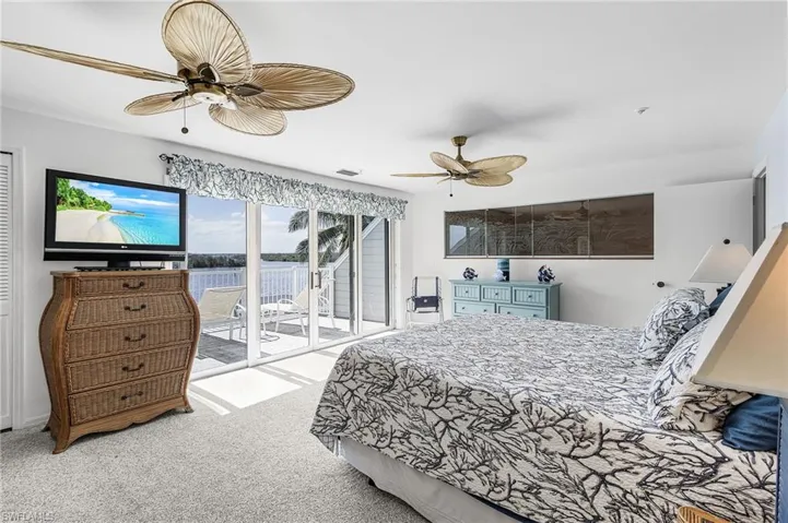 Bedroom with light colored carpet, access to exterior, and a ceiling fan