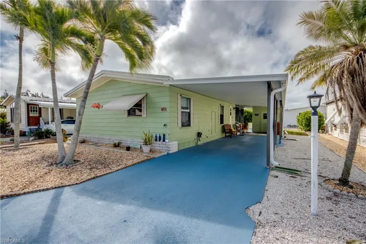 Manufactured / mobile home with driveway, an attached carport, and a patio