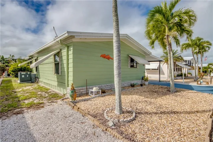View of side of property with crawl space and an attached carport