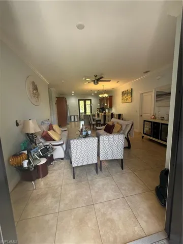 Living area featuring crown molding and light tile patterned floors