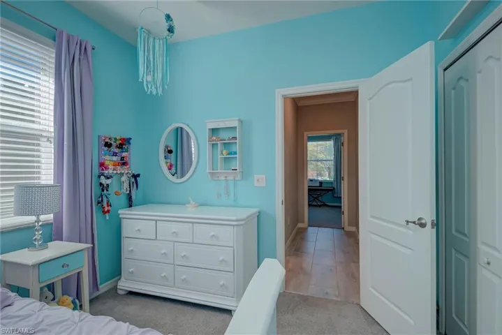 Bedroom with light carpet and a closet