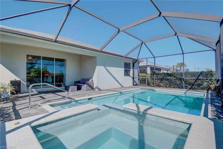 View of swimming pool featuring a sunroom, a pool with connected hot tub, a lanai, and a patio