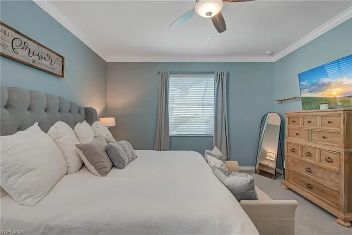 Bedroom featuring carpet flooring, ornamental molding, and ceiling fan