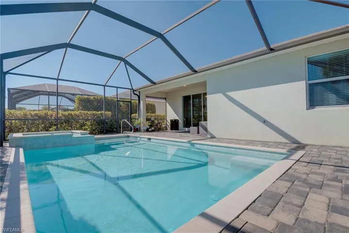 View of swimming pool with a patio area, a sunroom, a lanai, and a pool with connected hot tub