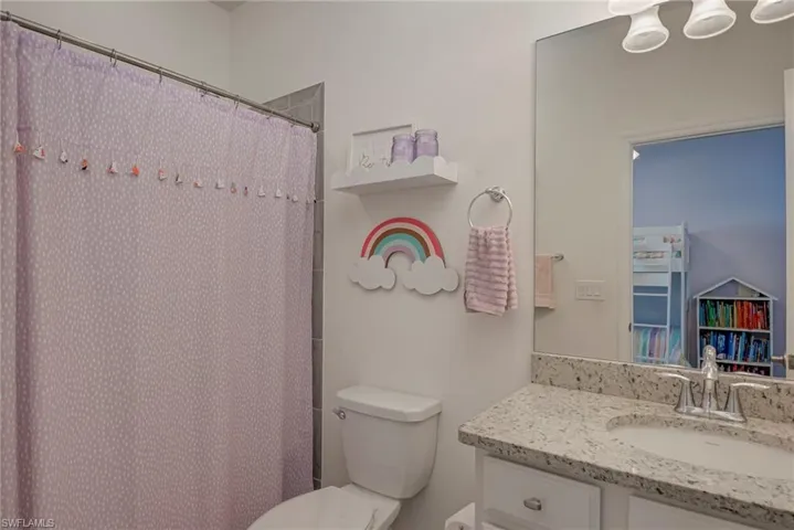 Bathroom with a shower with curtain and vanity