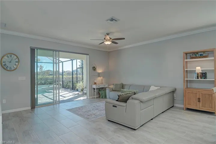 Living area with ornamental molding, ceiling fan, and wide plank tile floors