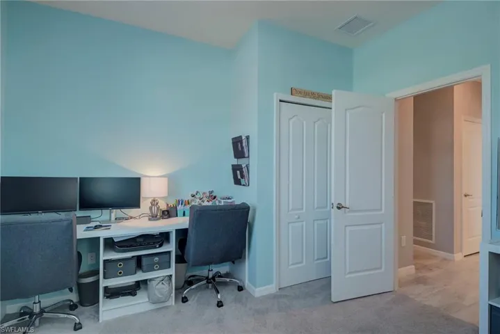 Office area featuring light carpet and baseboards