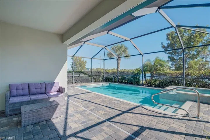 View of swimming pool featuring a patio area, a lanai, a sunroom, a pool with connected hot tub, and outdoor lounge area