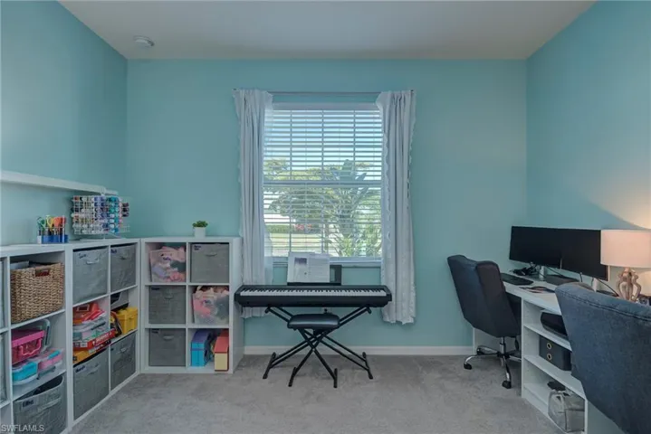 The guest bedroom currently used as Home office with light carpet