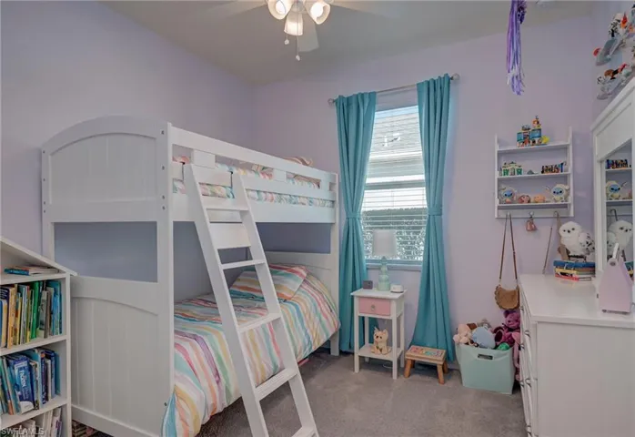Bedroom with light colored carpet and a ceiling fan