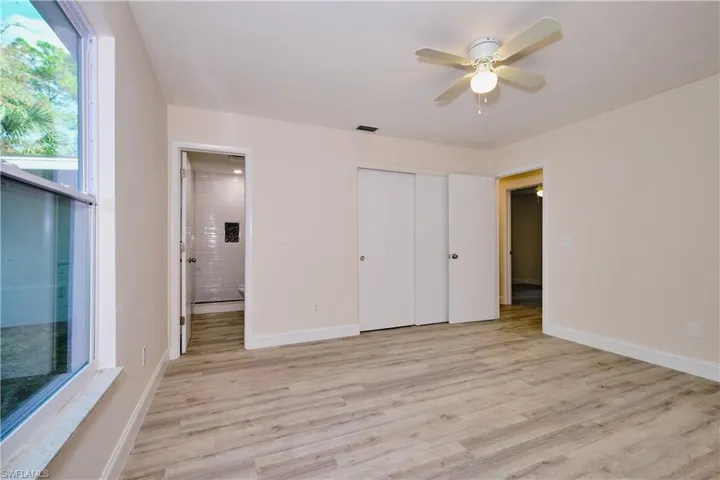 Unfurnished bedroom with light wood-type flooring, ceiling fan, and a closet