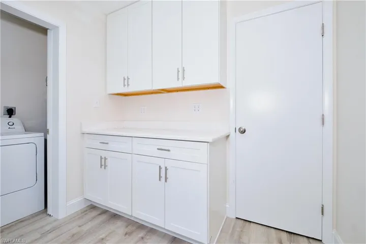 Laundry area featuring washer / clothes dryer and light wood finished floors