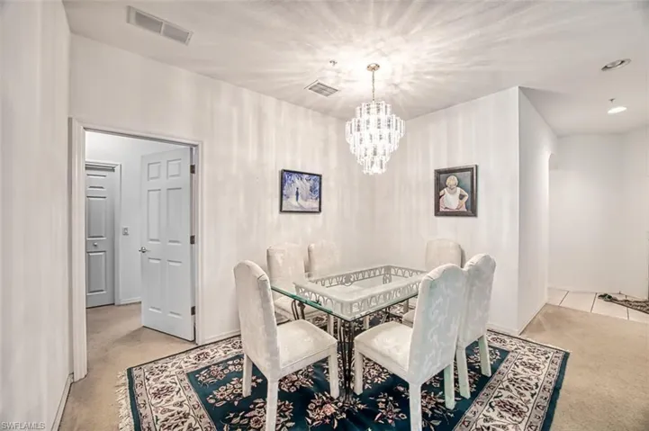 Carpeted dining room featuring an inviting chandelier