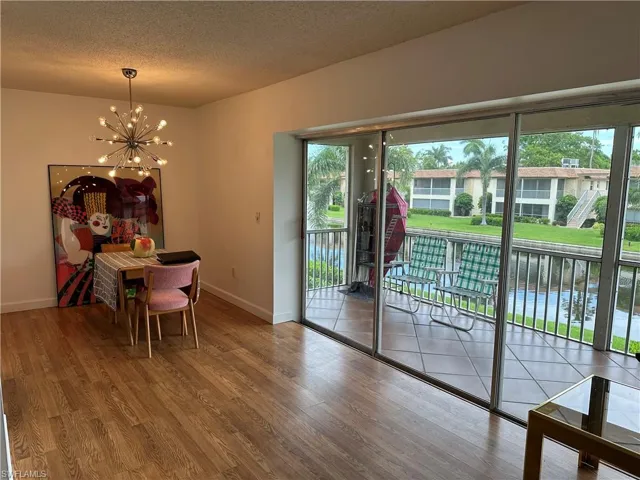 Dining room featuring a notable chandelier, a textured ceiling, and hardwood / wood-style floors